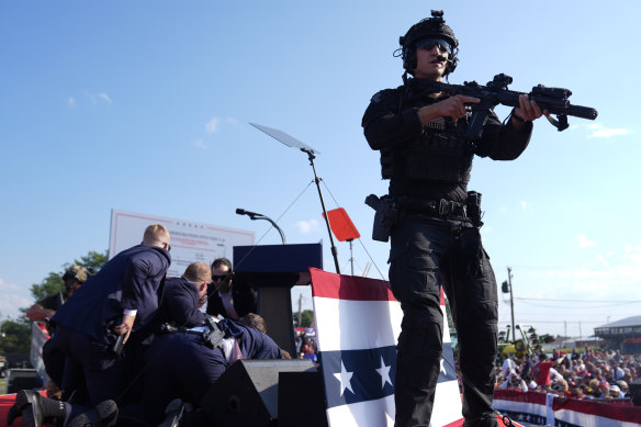 A Secret Service agents react to the shooting as others shield Donald Trump.