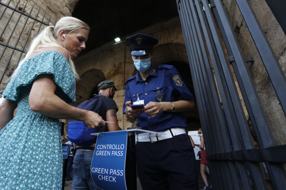 Tourists have their “green pass” checked by security staff at the entrance of the Colosseum in Rome, Italy, Friday, August 6, 2021.