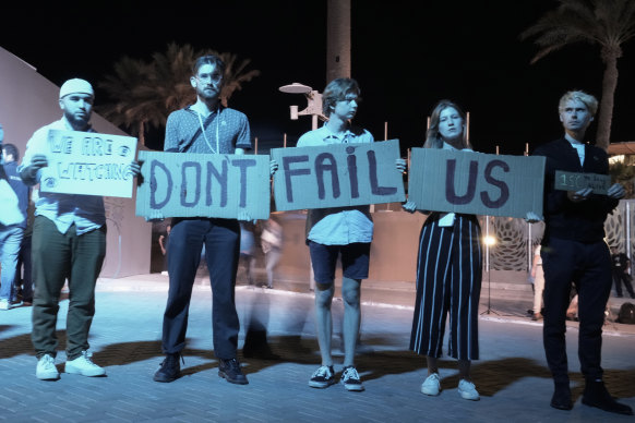 Activists hold signs at the COP27 UN Climate Summit on Saturday in Sharm el-Sheikh, Egypt. 