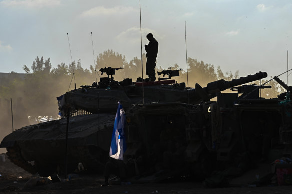 A soldier stands on top of a tank near Kibbutz Be’eeri near the Gaza Strip in Be’eeri, Israel.