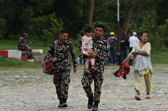 Nepalese soldiers assist survivors arriving at an army post in Bidur by helicopter.