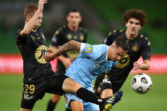 Melbourne City’s Jamie Maclaren is challenged by Daniel Wilmering of the Wanderers on Friday night.