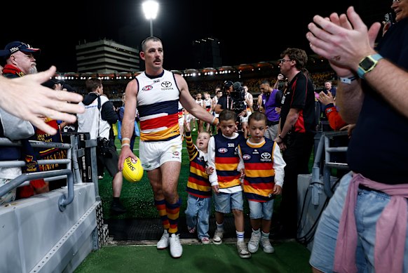 Walker leaves an AFL playing field for the final time with his children.