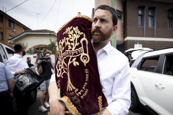 Chaim Klein carries a Torah scroll from Adass Israel synagogue on Friday afternoon.