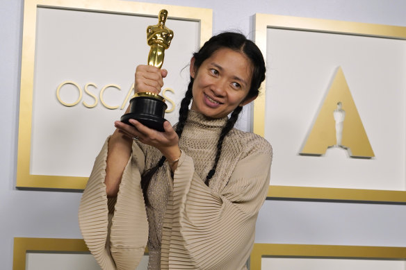 Nomadland director Chloe Zhao poses with one of her Oscars.