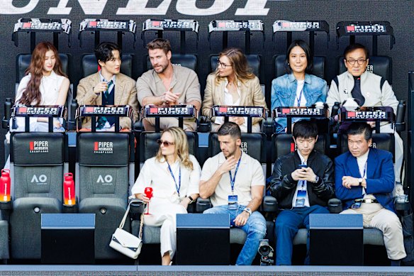 Liam Hemsworth e Jackie Chan (fila de trás) aproveitando seus assentos ao lado da quadra na final masculina de 2024.