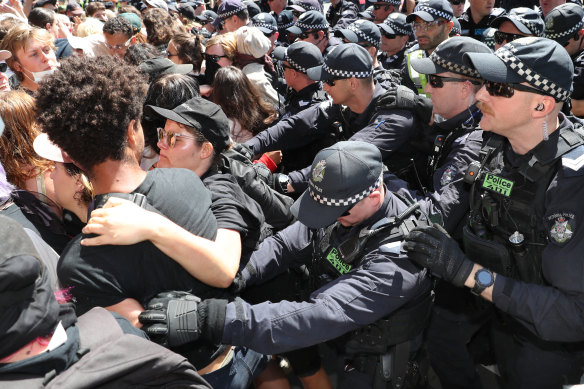 Police push back protesters outside the mining conference.