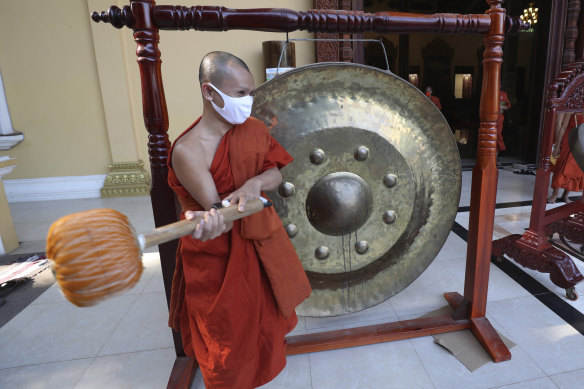 A Buddhist monk strikes a gong at a pagoda in Phnom Penh, Cambodia, to chase away the virus at the start of the pandemic.