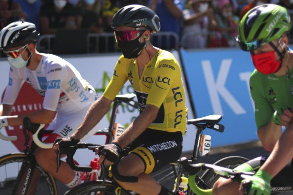 A masked Adam Yates, from Australian team Mitchelton-Scott, wears the yellow jersey as leader of the Tour de France.