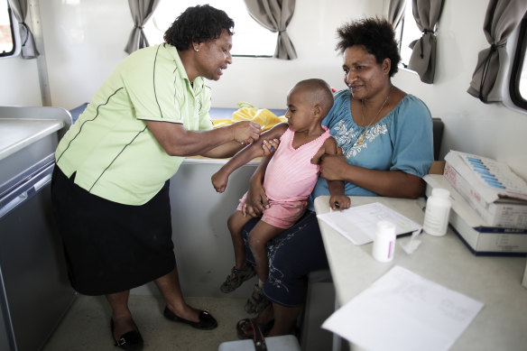 Wendy and three-year-old daughter Beverly, who is receiving her rubella vaccination at a mobile clinic operated by Susu Mamas.