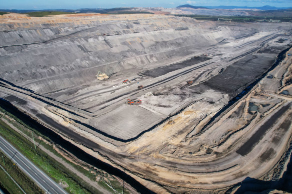 Steep walls plunge hundreds of metres to the floor of the Bengalla mine pit, where heavy machinery is put to work.