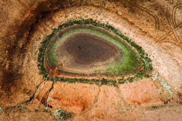 A windmill stands next to a dried-up dam on Australian farmer Ash Whitney’s drought-affected property located in the Goolhi area on the outskirts of Gunnedah, NSW, during the 2019 drought.
