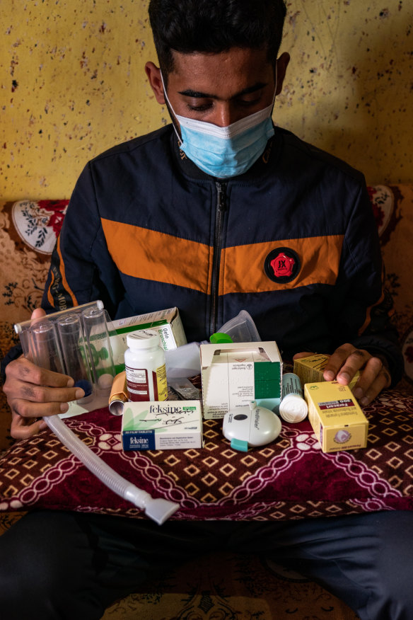 Louay Mohamed Majeed, 26, with all his medicine at home near the town of Balad, Iraq, on February 24. Majeed has lung cancer and lives in a dust-proof room to prevent his condition from worsening.