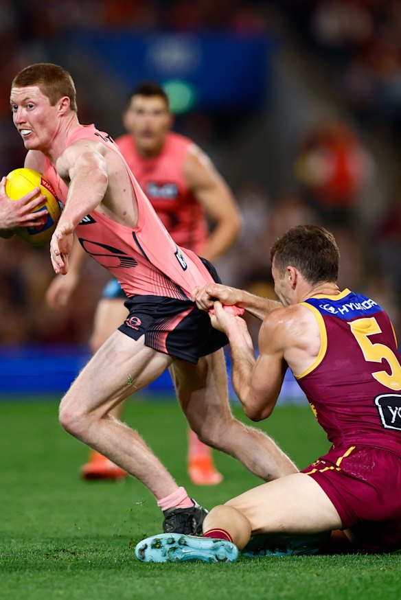 Matt Rowell of the Suns is tackled by Josh Dunkley of the Lions.