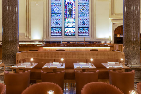 Tan leather and perforated timber booths help divide the grand dining room.