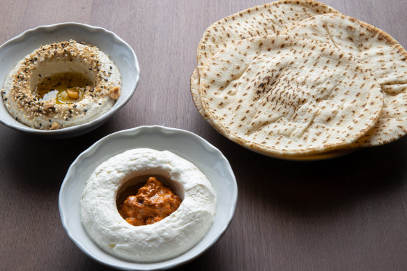 Almond taratour with dukkah (rear) and labne with muhammara, served with flatbreads.