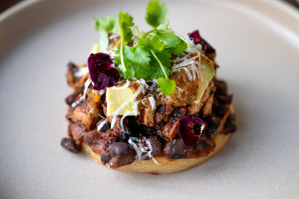 Memela del mercado, a tower of marrow beans and pork shoulder on a grilled maize flatbread.