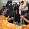 A mourner prays and weeps over the body of teacher Nanchanatporn Nakplang. 