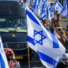 Thousands of people line the entrance to the Ayalon highway to watch and pay their respects as the funeral procession carrying the caskets of Shiri, Kfir and Ariel pass by with the family in minibuses behind them.