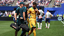 Mat Leckie leaves the field in the Socceroos' loss to the USA.