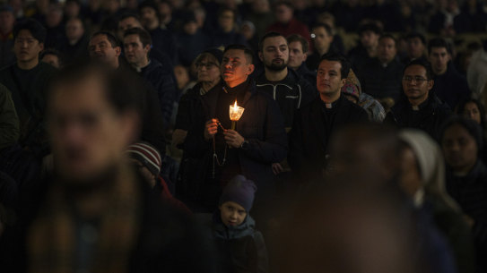 Worshippers recite the rosary for the Pope in St Peter’s Square at the Vatican on Monday night.