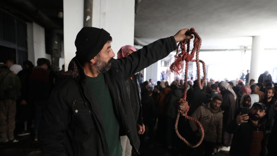 A man holds up rope at Sednaya Prison, where thousands of people were said to be detained and tortured.