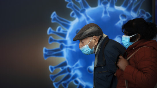 People wearing face masks wait to receive a coronavirus vaccine at a COVID-19 vaccination center in Jerusalem on Monday.