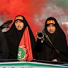 Women carrying weapons resembling shoulder-fired missiles ride in a truck during a pro-government National Army Day demonstration on April 17, 2026 in Tehran, Iran. 