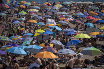 İspanya'nın Barselona kentinde Cuma günü insanlar sahile akın ediyor.