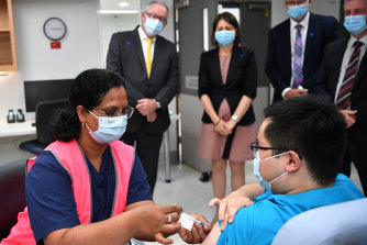 NSW Premier Gladys Berejiklian and Health Minister Brad Hazzard look on as NSW Health worker Andrew Santoso receives his COVID-19 vaccination at Westmead Hospital.