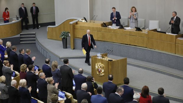 Russian President Vladimir Putin, centre, arrives to applause from the members of the State Duma.