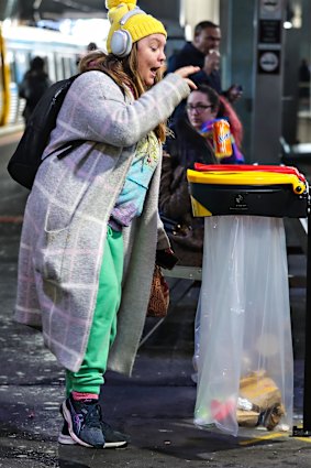 Commuter Erin Steele uses the rubbish and recycling bins at Southern Cross Station.