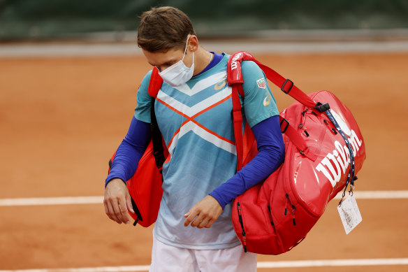 Short and sharp: Alex de Minaur leaves the court after losing to Marco Cecchinato in the first round.