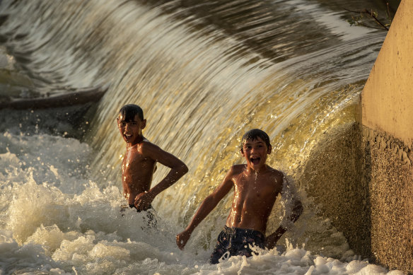 Water flows over Brewarrina Weir on Sunday.