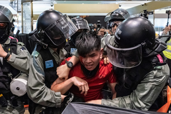 Riot police detain a man during protests at a shopping mall on Saturday. 