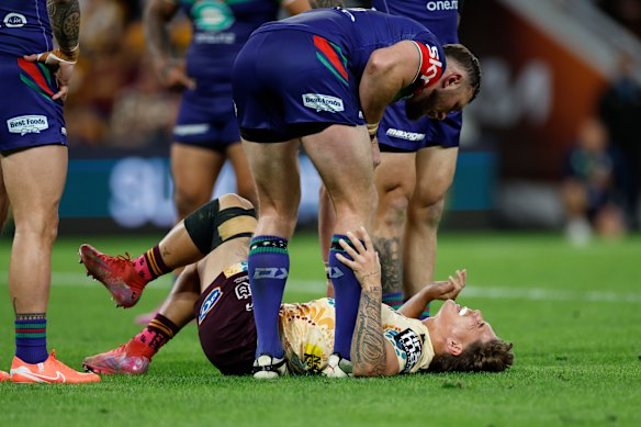 Reece Walsh lies injured during the round 24 match between the Broncos and the Warriors.