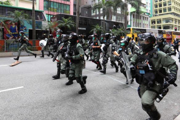 Riot police charge at demonstrators.