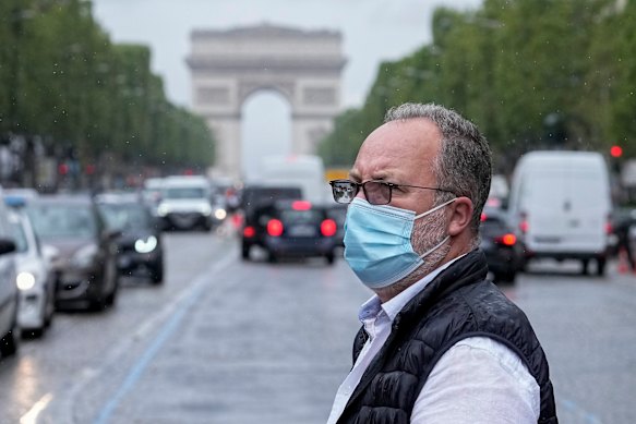 A man crosses the Champs Elysees avenue in Paris on Monday.