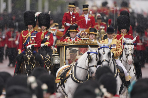 The King looks out from his rain-splattered carriage as he returns to Buckingham Palace.