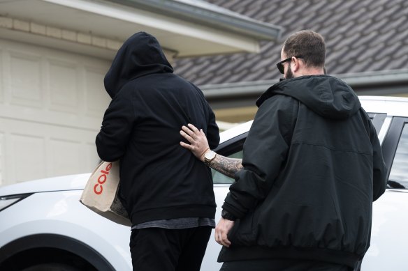 Brett Button arrives home wearing a black hoodie after being granted bail on Tuesday.