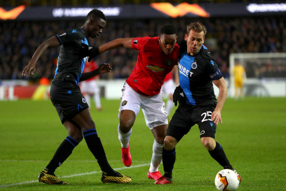 United's Anthony Martial is challenged by Club Brugge's Odilon Kossounou and Ruud Vormer.
