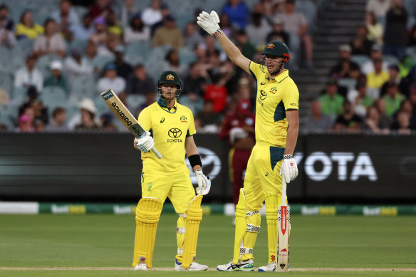 Steve Smith raises his bat and Cameron Green watches on.