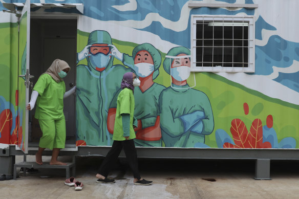 Health workers walk out of a mobile laboratory before analysing samples collected during mass coronavirus tests in Jakarta, Indonesia on Thursday.