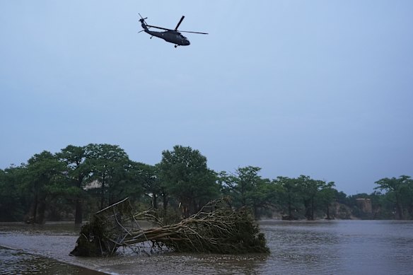 Un helicóptero vuela sobre el río Guadalupe inundado.