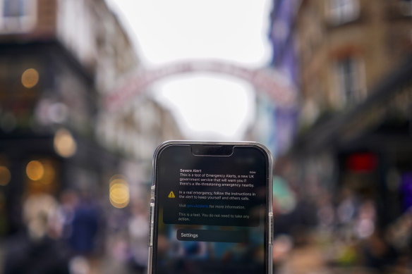 A smartphone displays the banner of an emergency alert system in London.