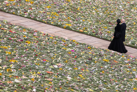 Mourners walk through a sea of flowers following the committal service.