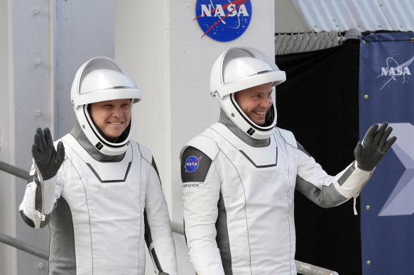 Roscosmos cosmo<em></em>naut Aleksandr Gorbunov (left) and NASA astro<em></em>naut Nick Hague wave as they leave the Operations and Checkout Building at Cape Canaveral, Florida, as they prepare for their mission to the Internatio<em></em>nal Space Station.