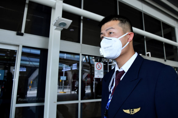China Eastern Airlines flight crew wear protective masks on arrival at Sydney International Airport on Thursday.