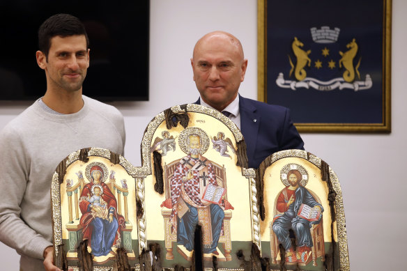 Serbian tennis player Novak Djokovic, left, poses with top local official Marko Carevic during a ceremony in the municipal building in Budva, Montenegro.
