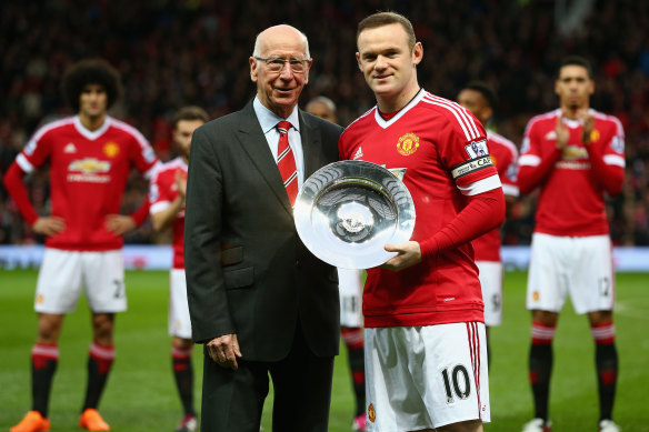 Wayne Rooney is presented with a trophy by Sir Bobby Charlton to mark his 500th game for Manchester United in 2015.